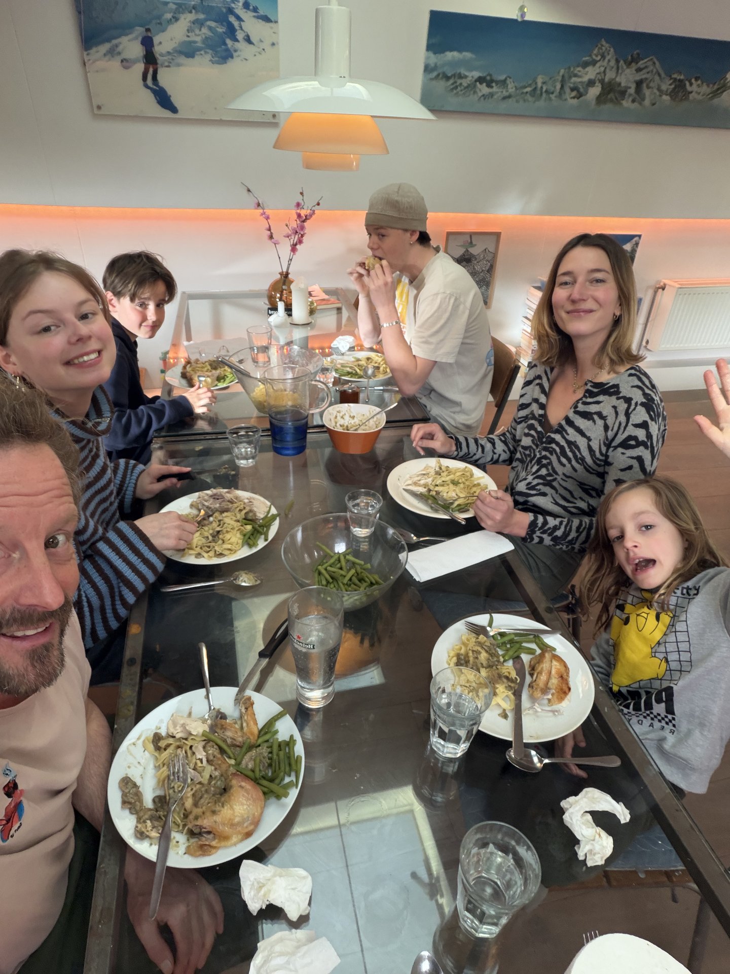 This photo captures a lively family dinner scene in what appears to be a home in Oudeschans, Uilenburg, Amsterdam